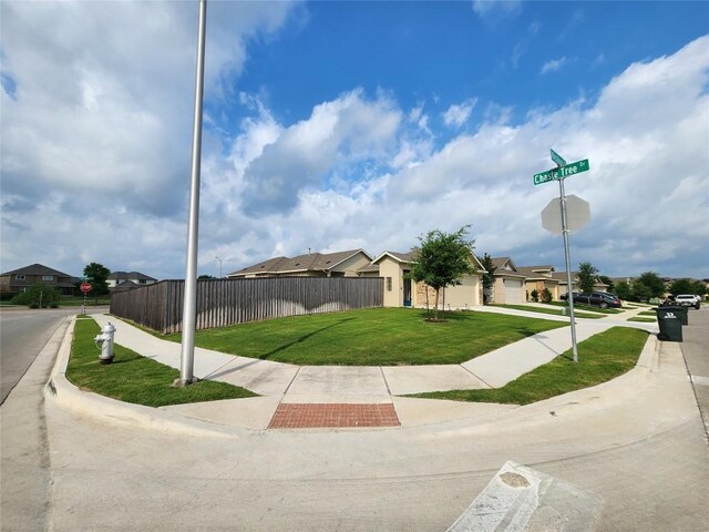 exterior space featuring a residential view, sidewalks, traffic signs, and curbs