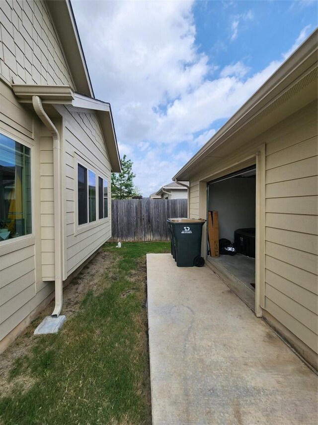 view of yard featuring fence, driveway, and a garage