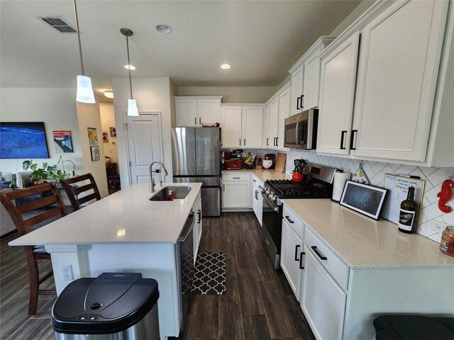 kitchen with backsplash, appliances with stainless steel finishes, a sink, and visible vents