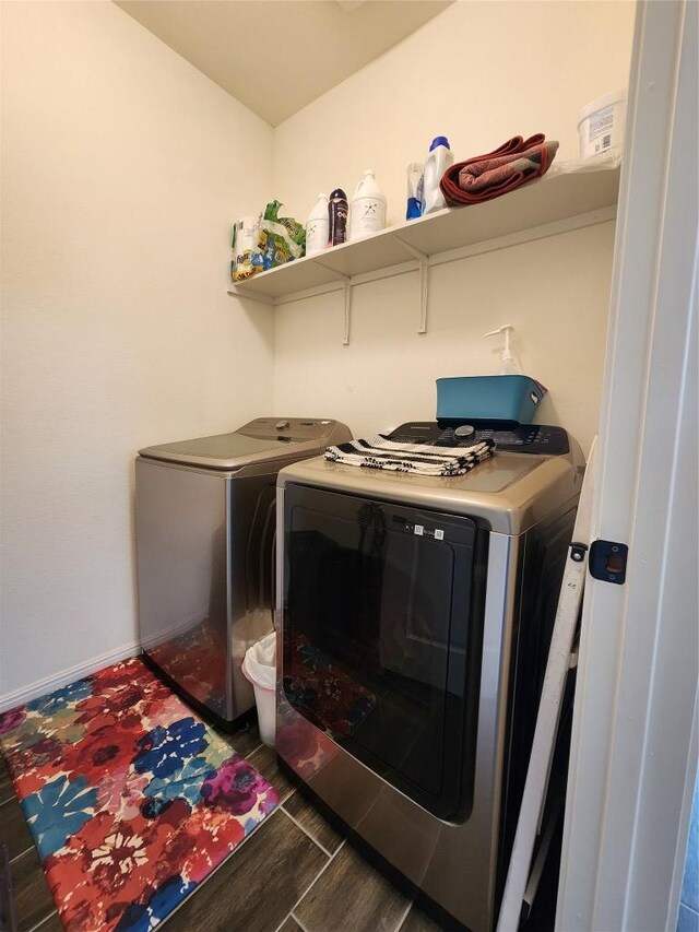 clothes washing area featuring separate washer and dryer, laundry area, baseboards, and wood finished floors