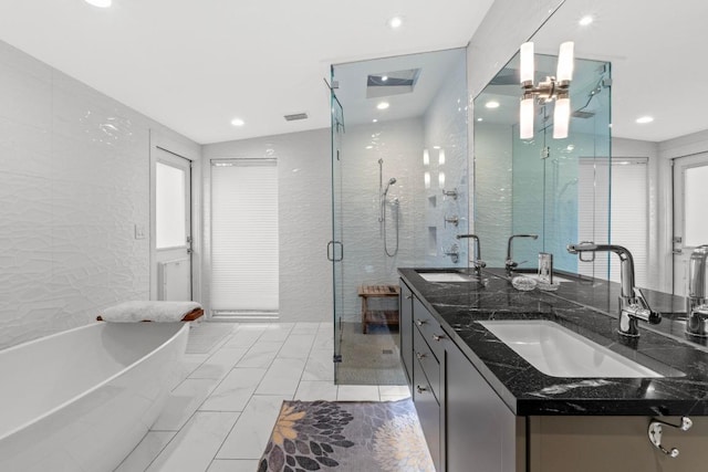 1705 Westmoor Dr, Austin, TX 78723 - full bath featuring double vanity, a freestanding tub, a shower stall, marble look tiles, and recessed lighting