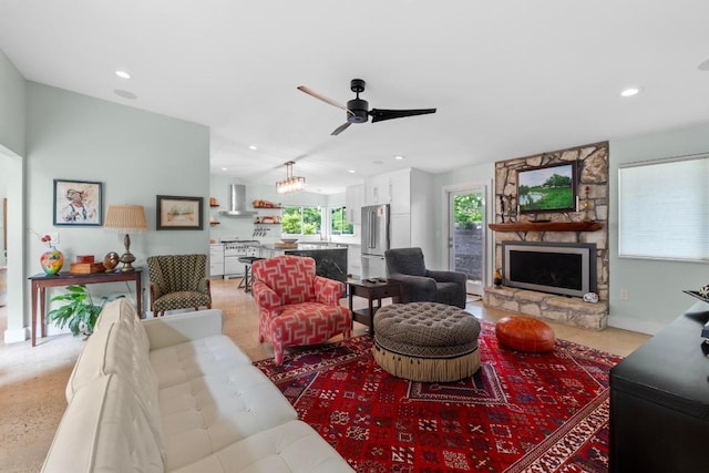 living room with a stone fireplace, recessed lighting, and ceiling fan