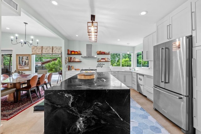kitchen with open shelves, wall chimney range hood, a sink, a notable chandelier, and stainless steel appliances