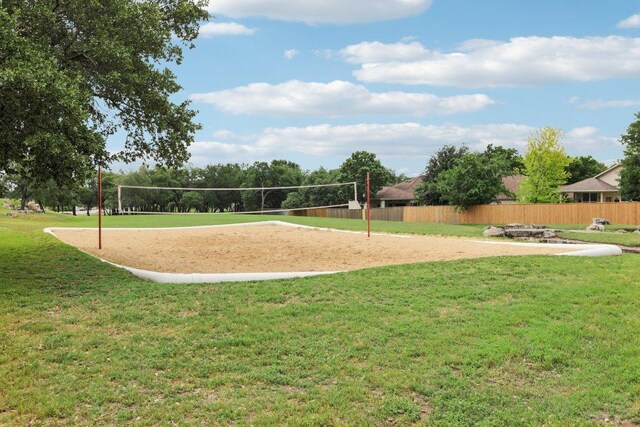 surrounding community featuring a lawn, fence, and volleyball court