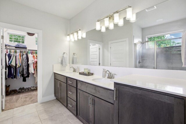 bathroom featuring a sink, plenty of natural light, a stall shower, and visible vents