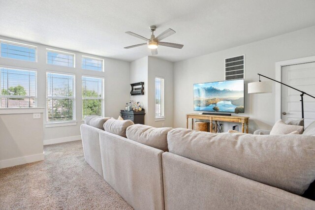 carpeted living room featuring a ceiling fan and baseboards