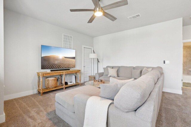 carpeted living area featuring ceiling fan, visible vents, and baseboards