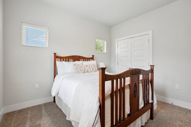 carpeted bedroom featuring a closet and baseboards