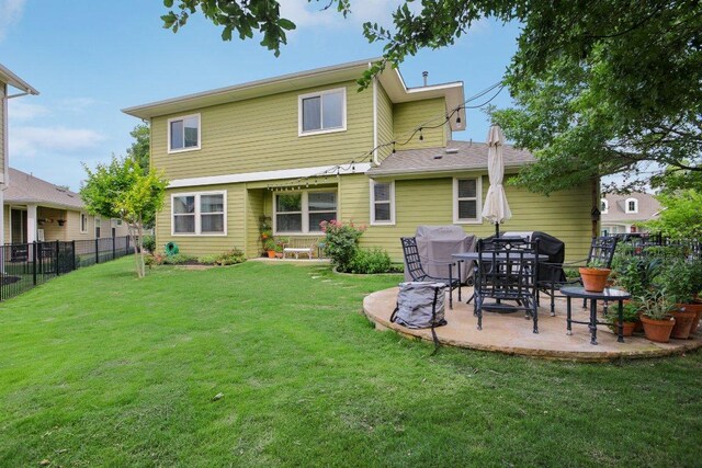 rear view of property featuring a lawn, a fenced backyard, and a patio area