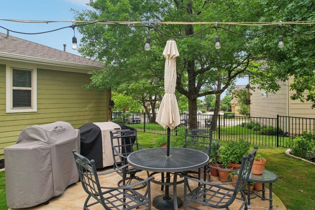 view of patio / terrace featuring fence, outdoor dining space, and a grill