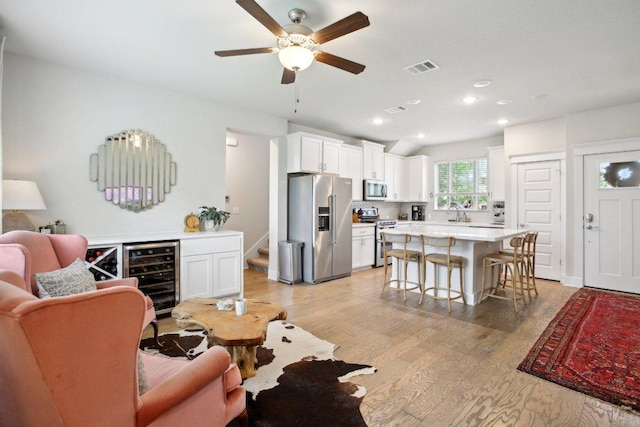 1708 Loyal Friend Dr Unit 46, Leander, TX 78641 - living area with wine cooler, light wood-type flooring, a ceiling fan, stairs, and recessed lighting
