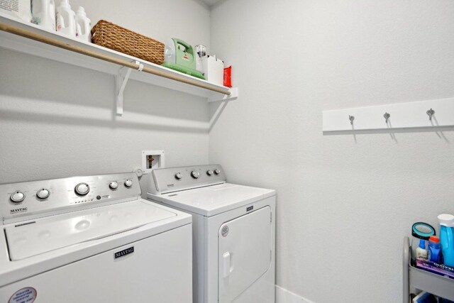 clothes washing area with separate washer and dryer and laundry area