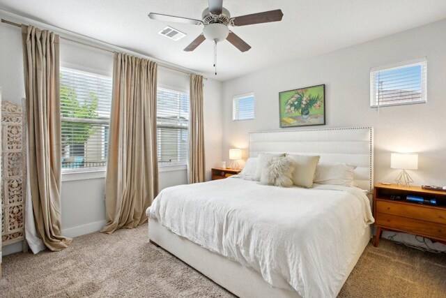 bedroom featuring carpet floors, a ceiling fan, baseboards, and visible vents