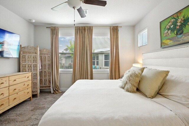 carpeted bedroom featuring a ceiling fan and visible vents