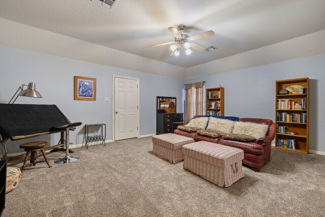 carpeted living area featuring baseboards, a ceiling fan, and visible vents
