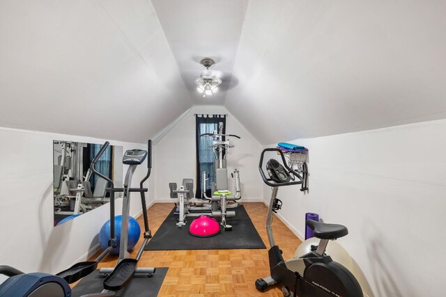 workout room featuring baseboards and vaulted ceiling