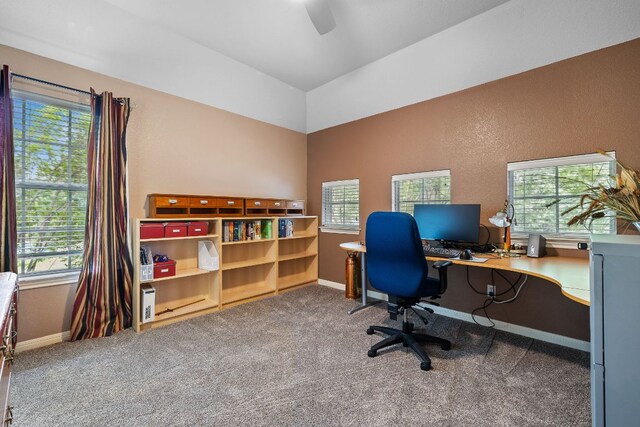 carpeted home office with baseboards, a ceiling fan, a wealth of natural light, and vaulted ceiling