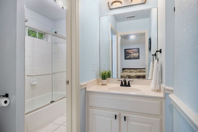 ensuite bathroom with tile patterned flooring, visible vents, vanity, shower / bath combination with glass door, and ensuite bathroom