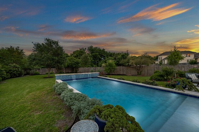 pool at dusk with a lawn, a fenced backyard, and a fenced in pool