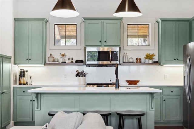 bar featuring pendant lighting, appliances with stainless steel finishes, plenty of natural light, and a sink