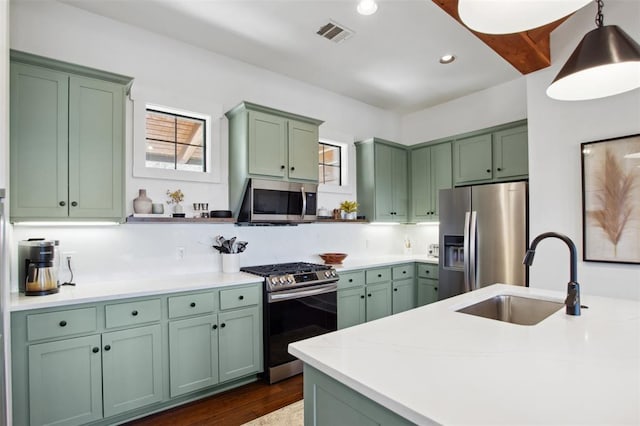 kitchen with visible vents, a sink, green cabinets, stainless steel appliances, and recessed lighting