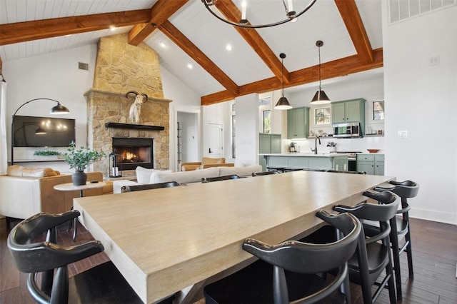 kitchen with high vaulted ceiling, beamed ceiling, dark wood-style floors, green cabinetry, and stainless steel appliances