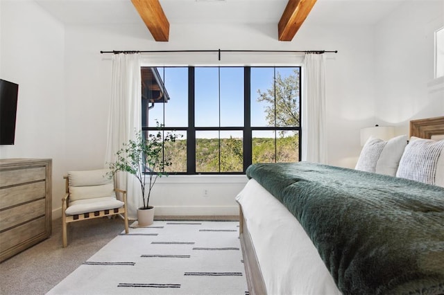 bedroom featuring baseboards, carpet, beam ceiling, and multiple windows