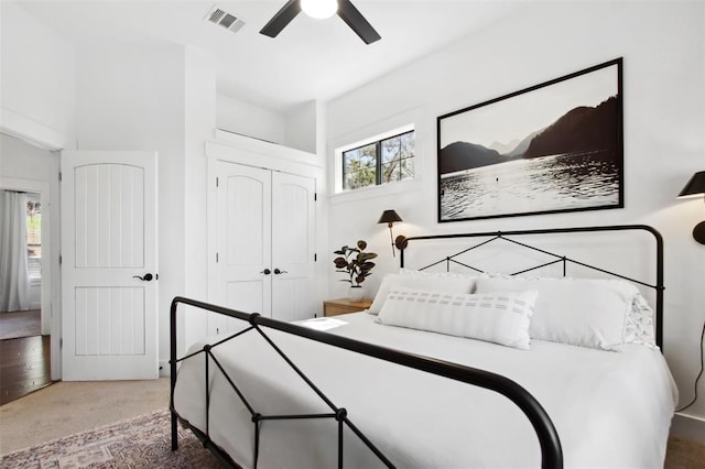 carpeted bedroom with a ceiling fan, visible vents, and a closet