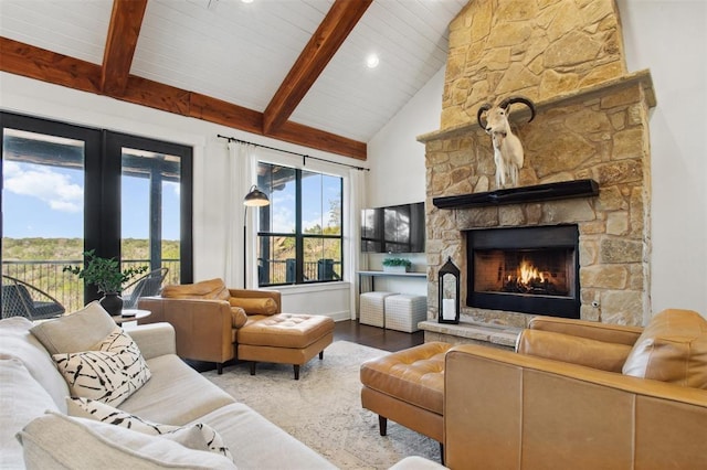living area with beam ceiling, high vaulted ceiling, wood finished floors, and a fireplace