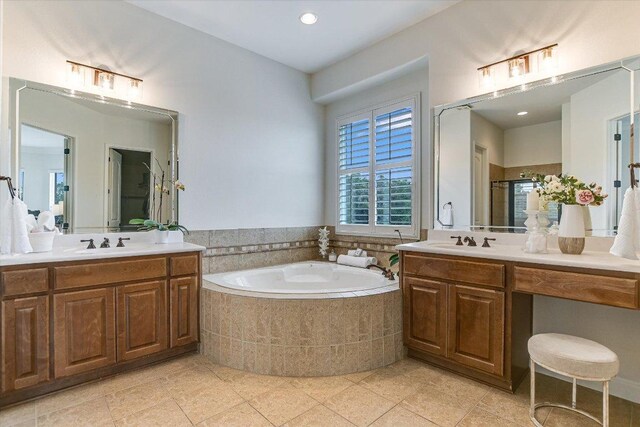 full bath with a sink, tile patterned floors, a garden tub, and a stall shower