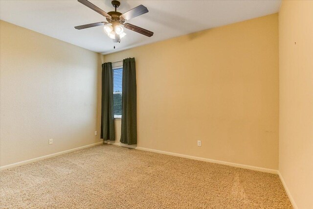 unfurnished room with baseboards, a ceiling fan, and light colored carpet