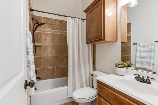 bathroom with shower / bath combo with shower curtain, toilet, and vanity