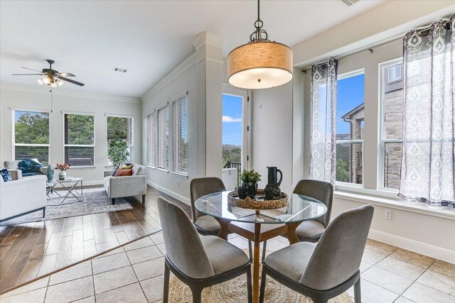 dining space featuring crown molding, baseboards, a ceiling fan, and a wealth of natural light