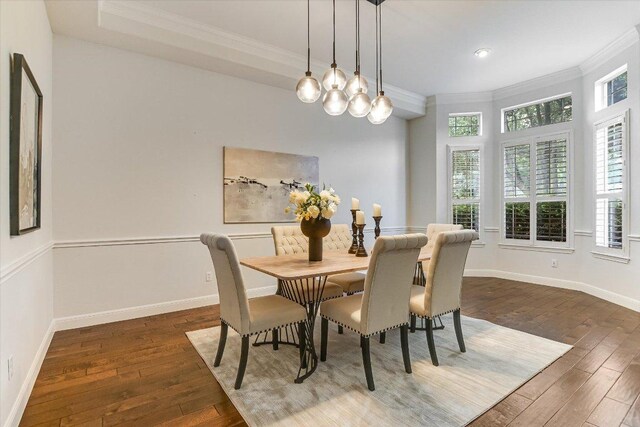 dining room with baseboards, ornamental molding, hardwood / wood-style flooring, and a chandelier