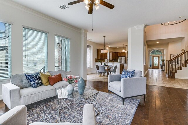 living area with a ceiling fan, visible vents, baseboards, stairs, and hardwood / wood-style floors