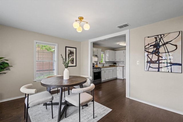 406 W 55th 1/2 St, Austin, TX 78751 - dining room with baseboards, dark wood-style floors, and a chandelier