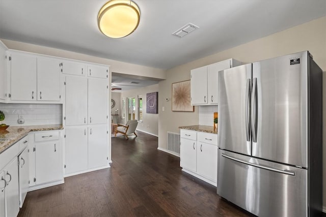 406 W 55th 1/2 St, Austin, TX 78751 - kitchen featuring freestanding refrigerator, dark wood-type flooring, decorative backsplash, and white cabinets