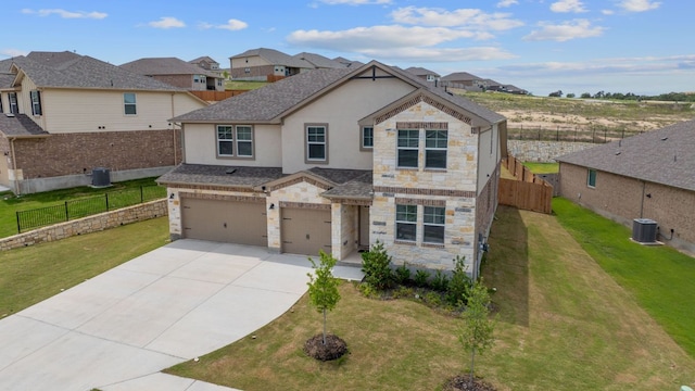 571 Sue Peaks Loop, Dripping Springs, TX 78620 - view of front facade featuring an attached garage, stone siding, stucco siding, central AC unit, and driveway