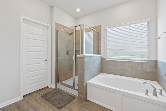 571 Sue Peaks Loop, Dripping Springs, TX 78620 - full bathroom featuring a stall shower, a garden tub, and wood finished floors