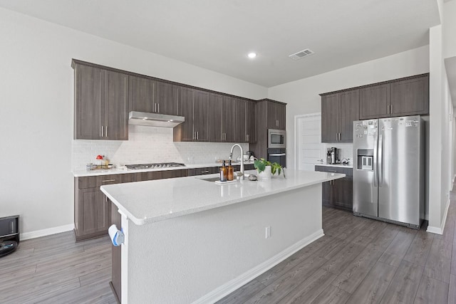 571 Sue Peaks Loop, Dripping Springs, TX 78620 - kitchen with dark brown cabinets, appliances with stainless steel finishes, a sink, decorative backsplash, and visible vents