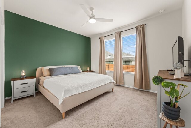 carpeted bedroom featuring baseboards and ceiling fan