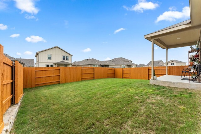 view of yard featuring a patio, a fenced backyard, and a residential view