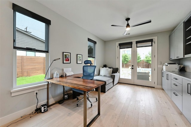 office space with plenty of natural light, french doors, and light wood-style flooring