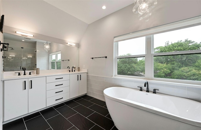 full bathroom featuring double vanity, a sink, a stall shower, and tile walls