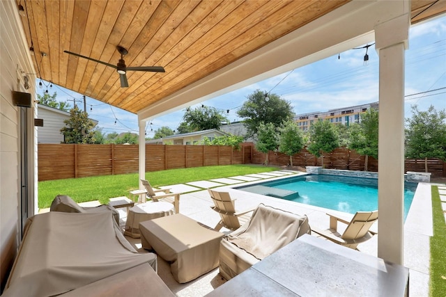 view of swimming pool with a fenced backyard, a ceiling fan, a fenced in pool, and a lawn