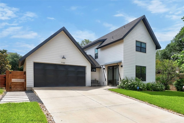 7103 Daugherty St, Austin, TX 78757 - view of front of home featuring driveway, a garage, a front lawn, and roof with shingles