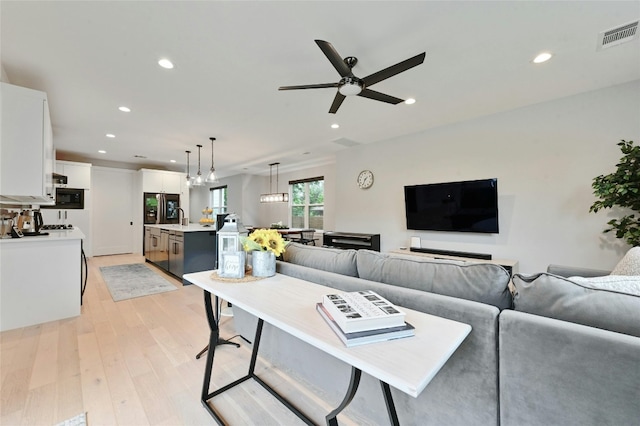 7103 Daugherty St, Austin, TX 78757 - living area featuring light wood finished floors, ceiling fan, and recessed lighting