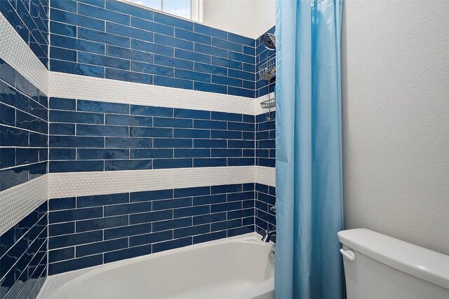 bathroom with toilet and shower / tub combo with curtain
