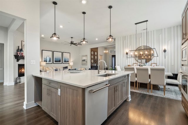 5812 Antelope Well Ln, Austin, TX 78738 - kitchen with a sink, dishwasher, open floor plan, light countertops, and a fireplace