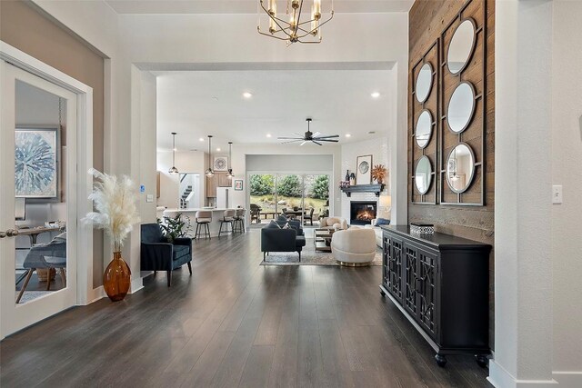 foyer entrance featuring recessed lighting, a fireplace, ceiling fan with notable chandelier, and dark wood-style flooring